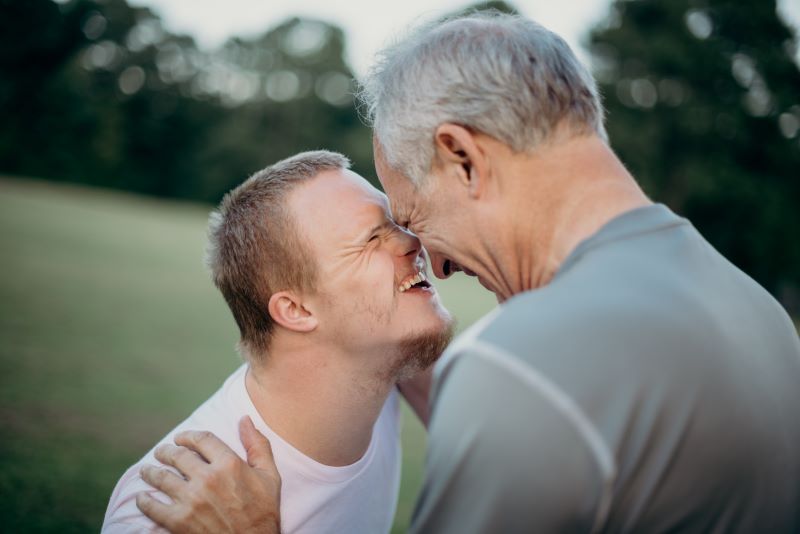 Two men, one old, one younger, standing face to face