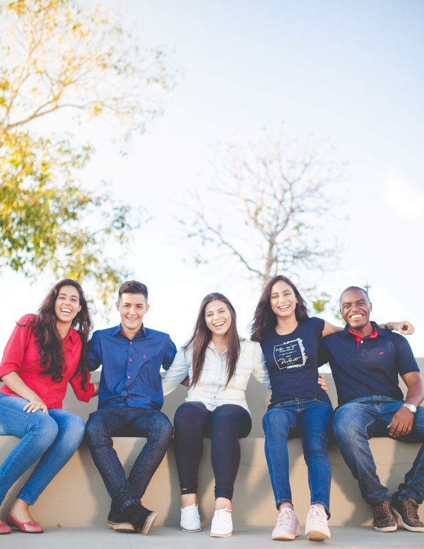 A group of five people sitting outside on a sunny day